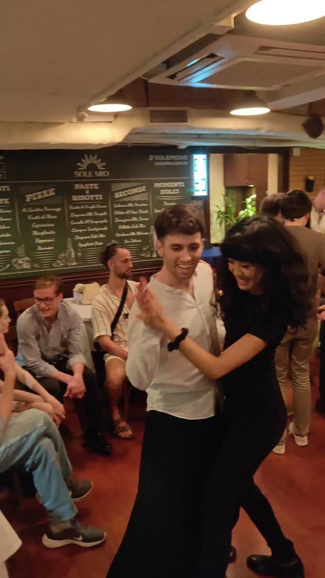 A couple dancing together in a vibrant indoor space.