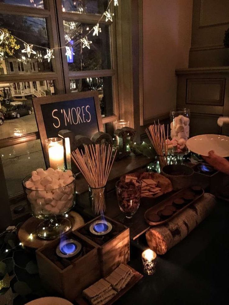 A s'mores station with marshmallows, chocolate, graham crackers, and a small tabletop burner.